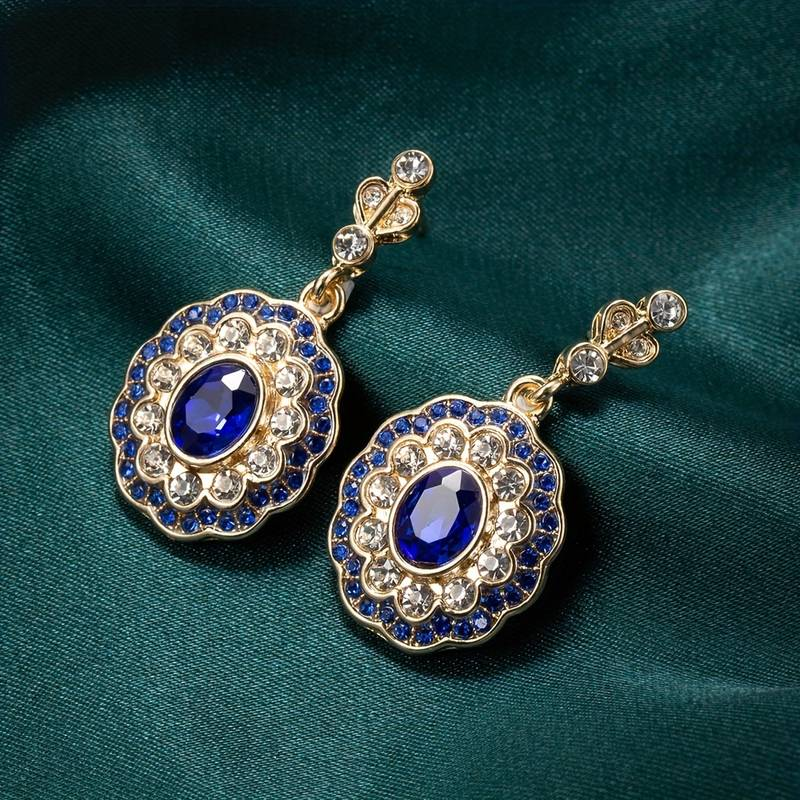 Oorbellen met een mandala van blauwe kristallen op vintage gouden hangers