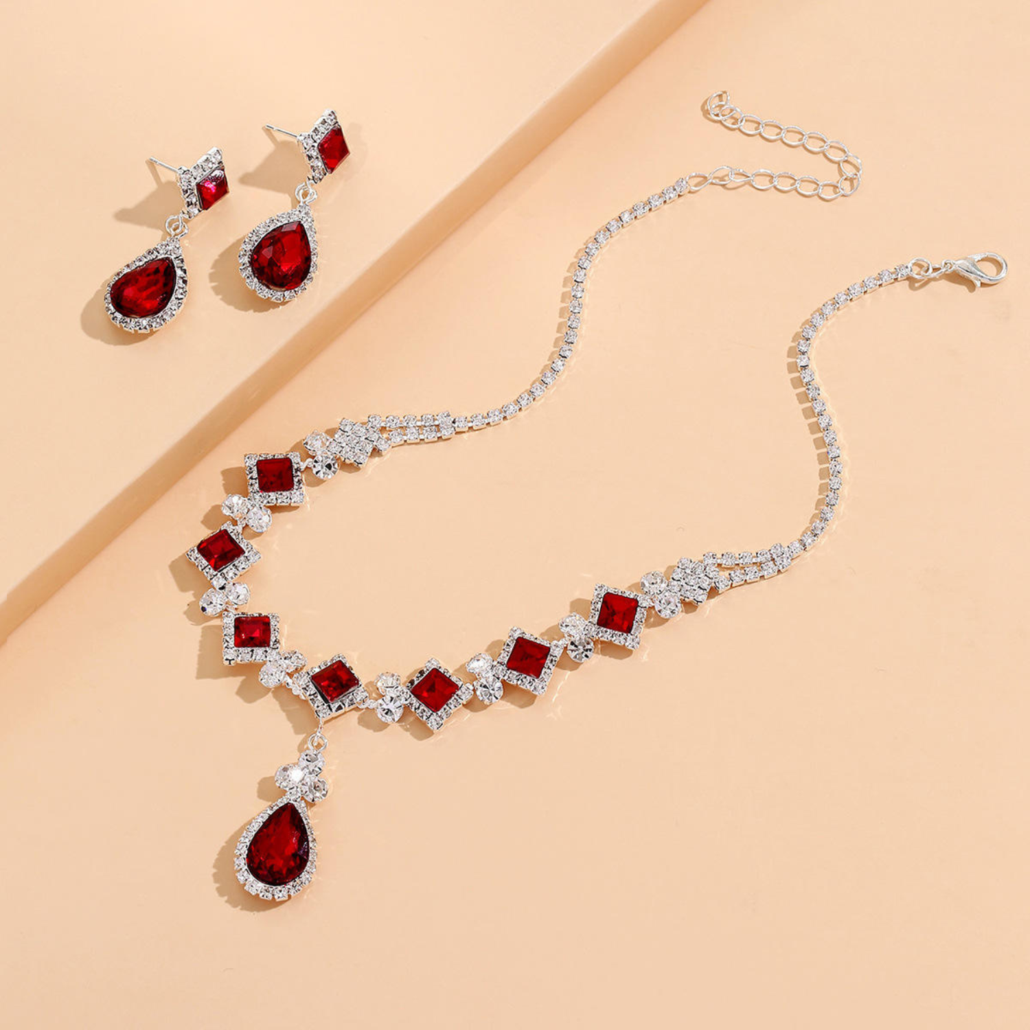 Set bestaande uit een choker met rode waterdruppels en bijpassende oorbellen.