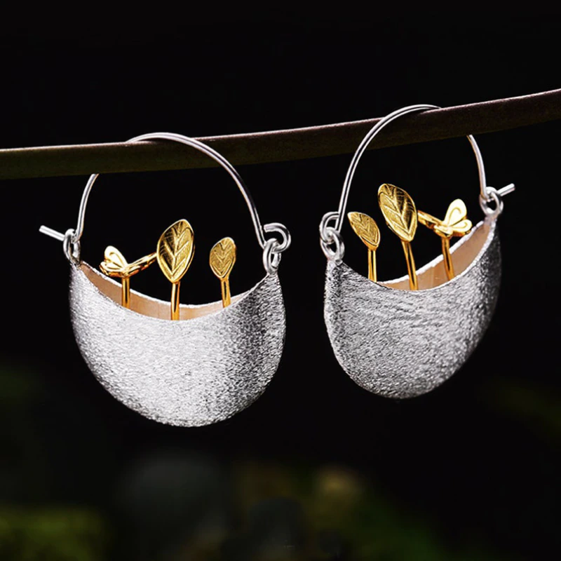 Vergulde oorbellen in de vorm van een bloemenmandje in zilver.