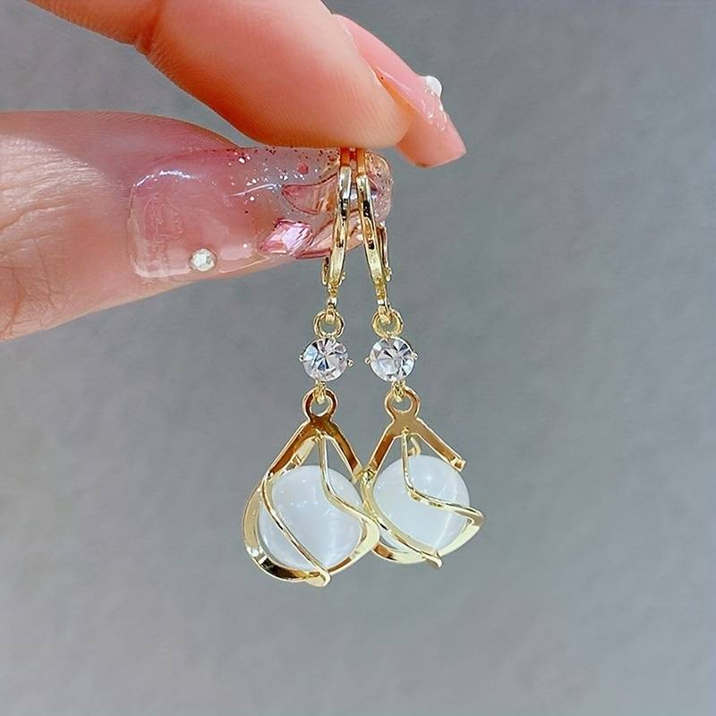 Vintage oorbellen met witte opaal en gouden hangertjes