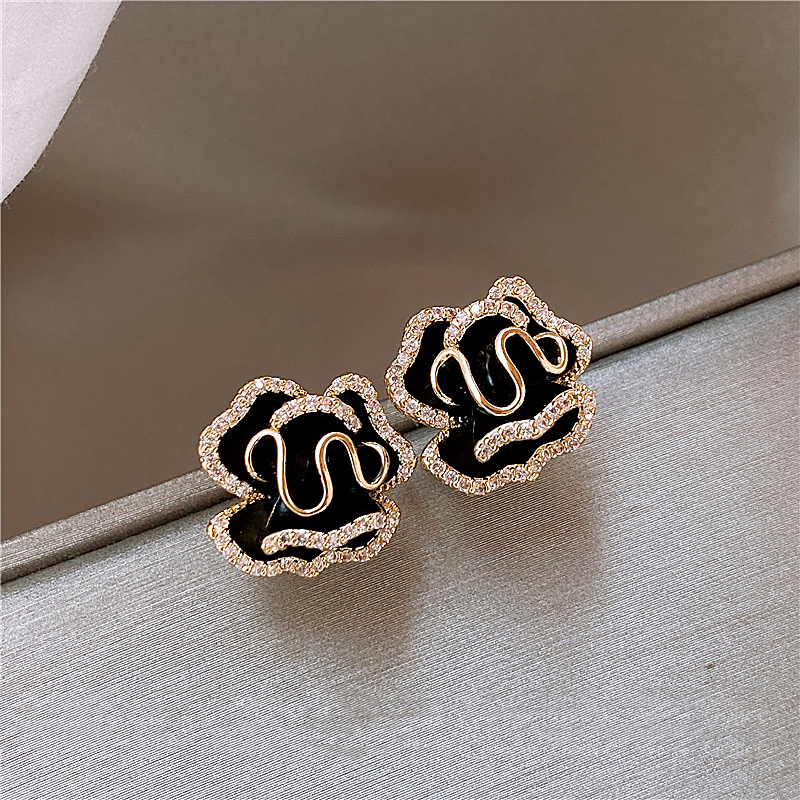 Elegante zwarte lotus oorbellen in goud
