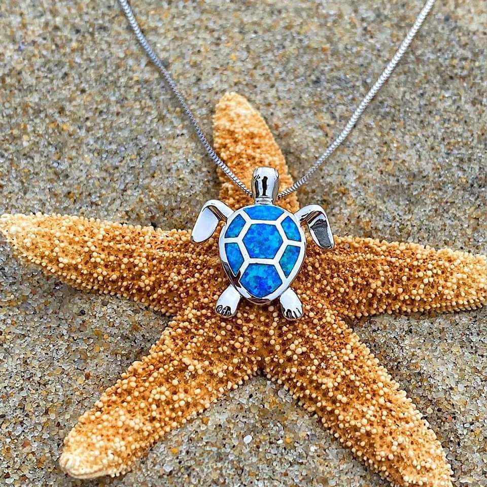 Set van ketting en oorbellen met zeeschildpadmotief, bezet met opaal en zilver.
